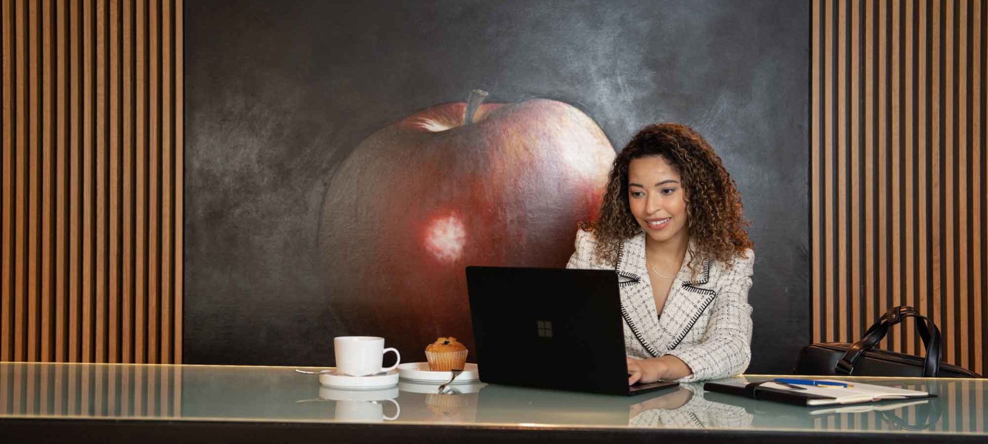 A Person Sitting At A Table With A Laptop