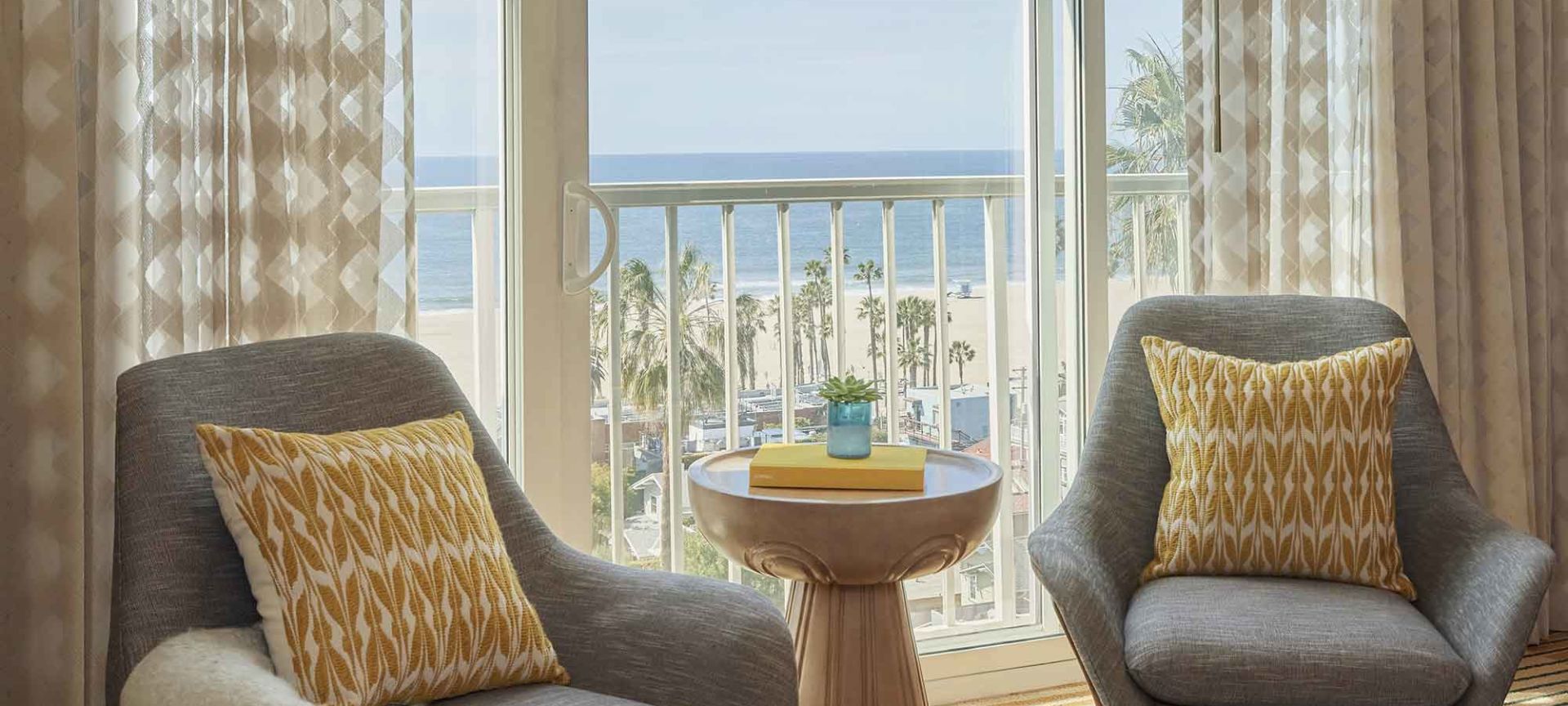 A Room With A Table Chairs And A Window With A View Of The Ocean