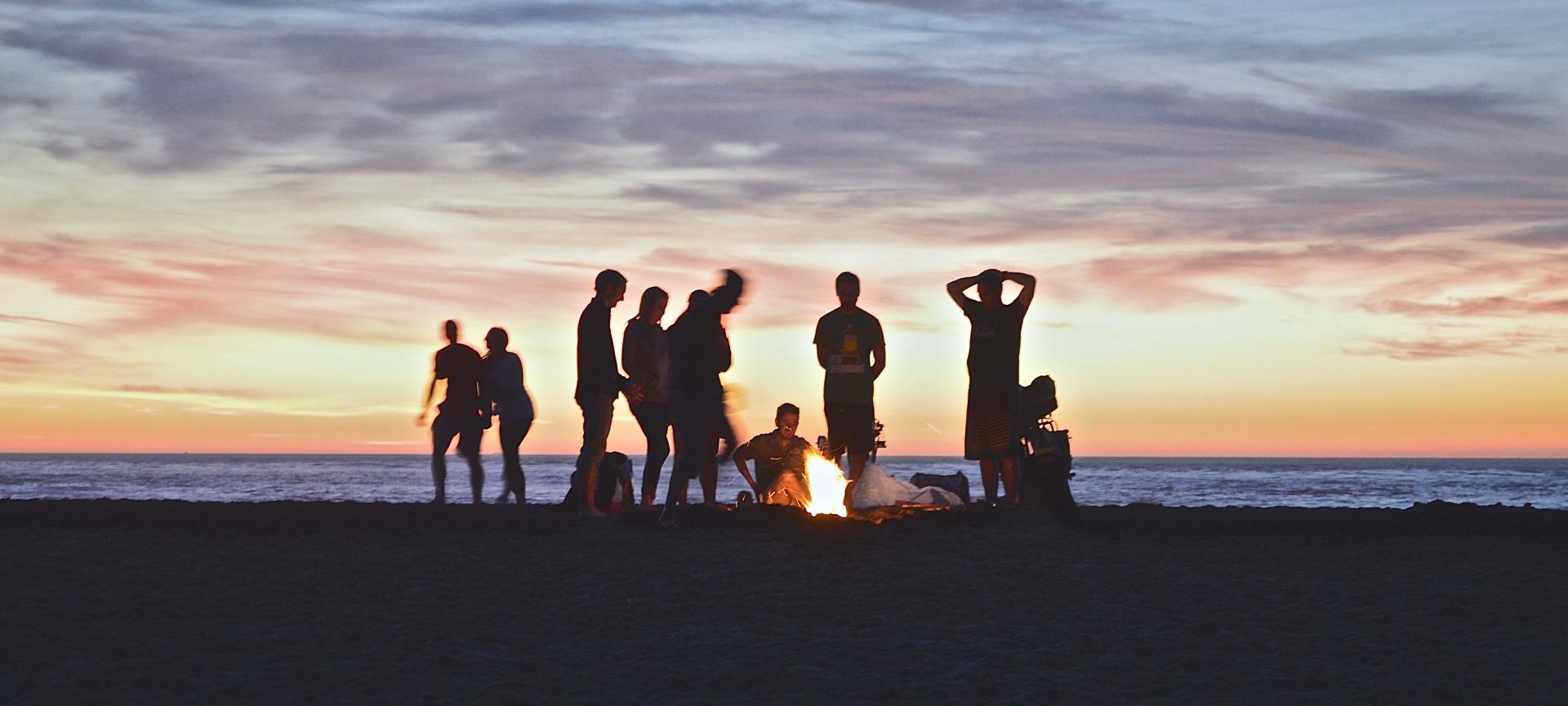 A Group Of People On A Beach Near A Body Of Water