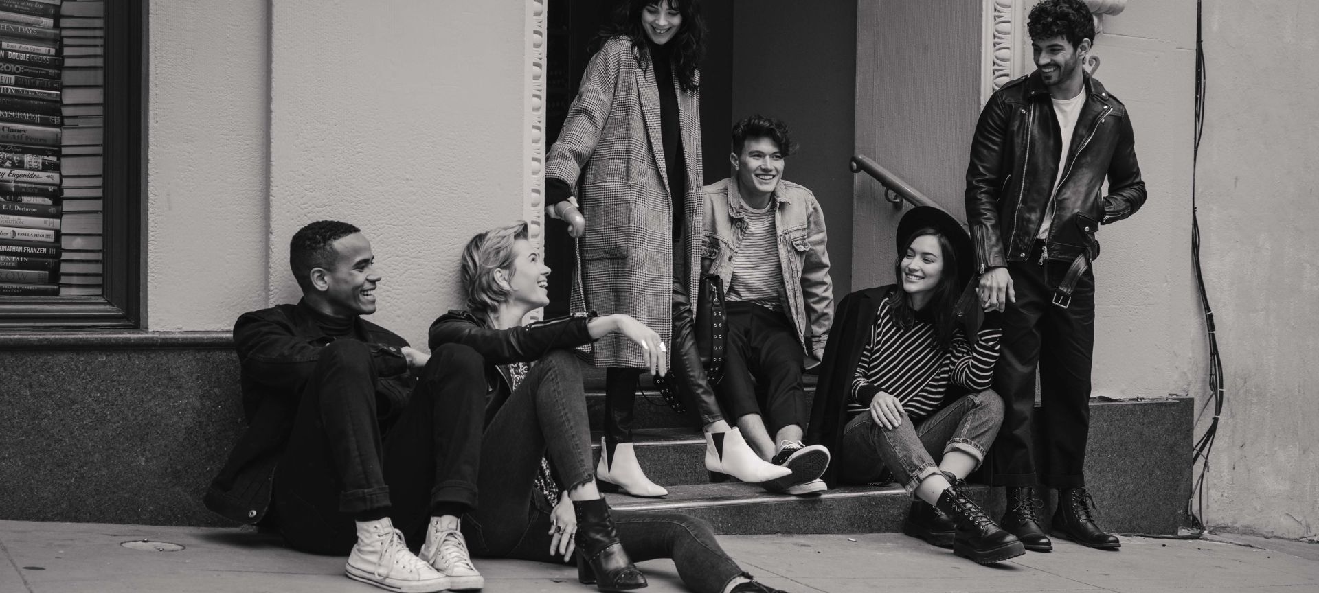 A Group Of People Sitting On The Side Of A Building