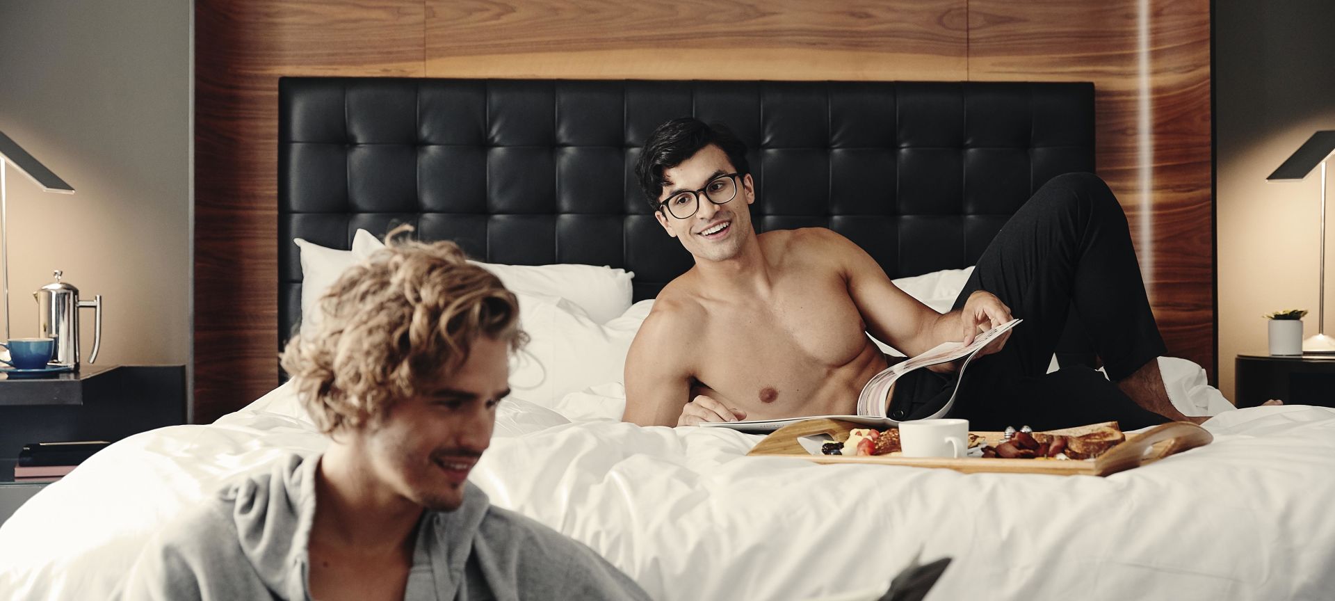 Two Men in a Hotel Room Reading