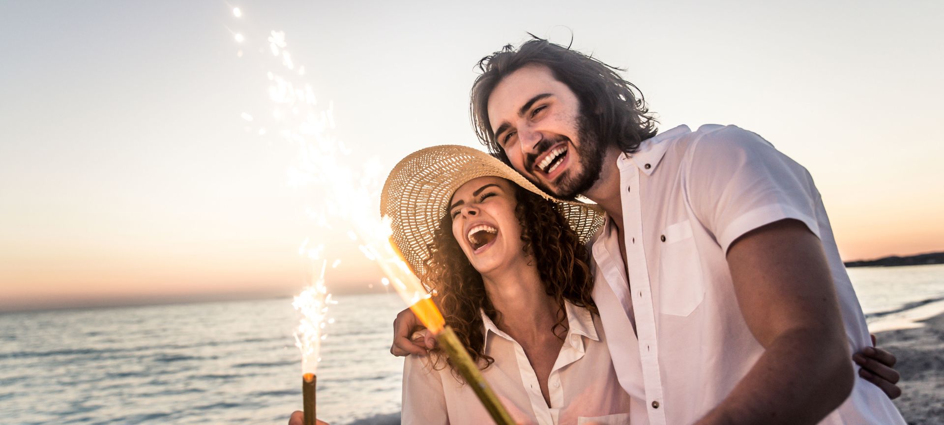 Couple on Beach with Sparklers in Their Hands