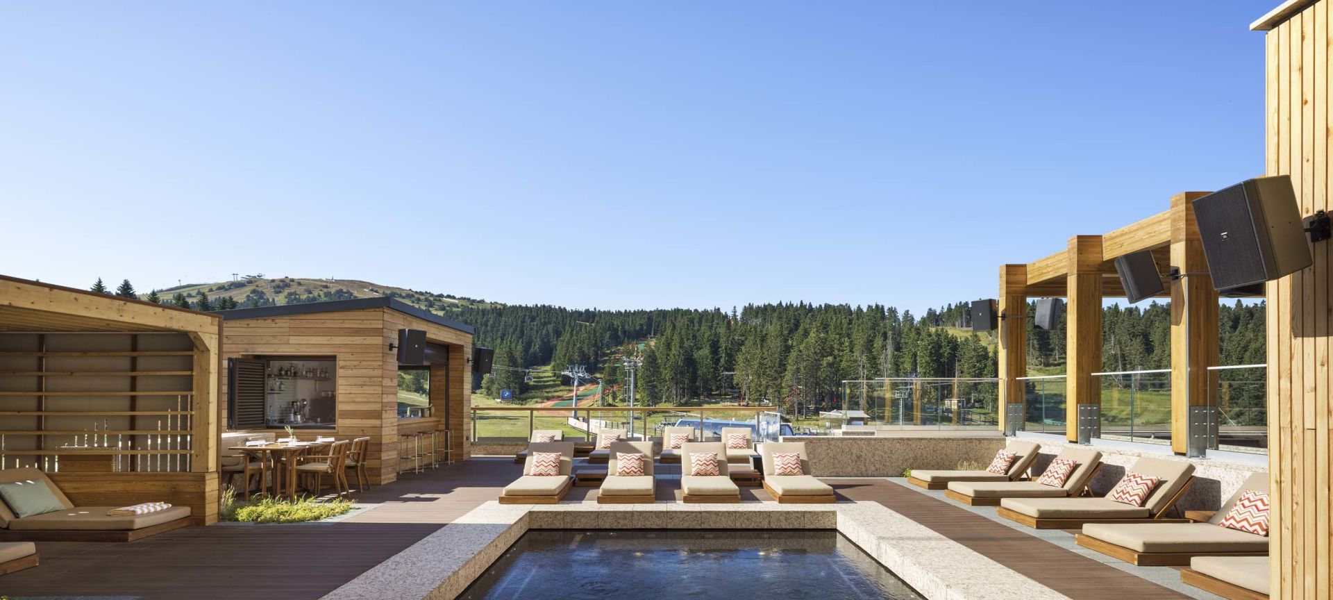 Otvoreni hidromasažni bazen sa mestima za sedenje i pogledom na planinu