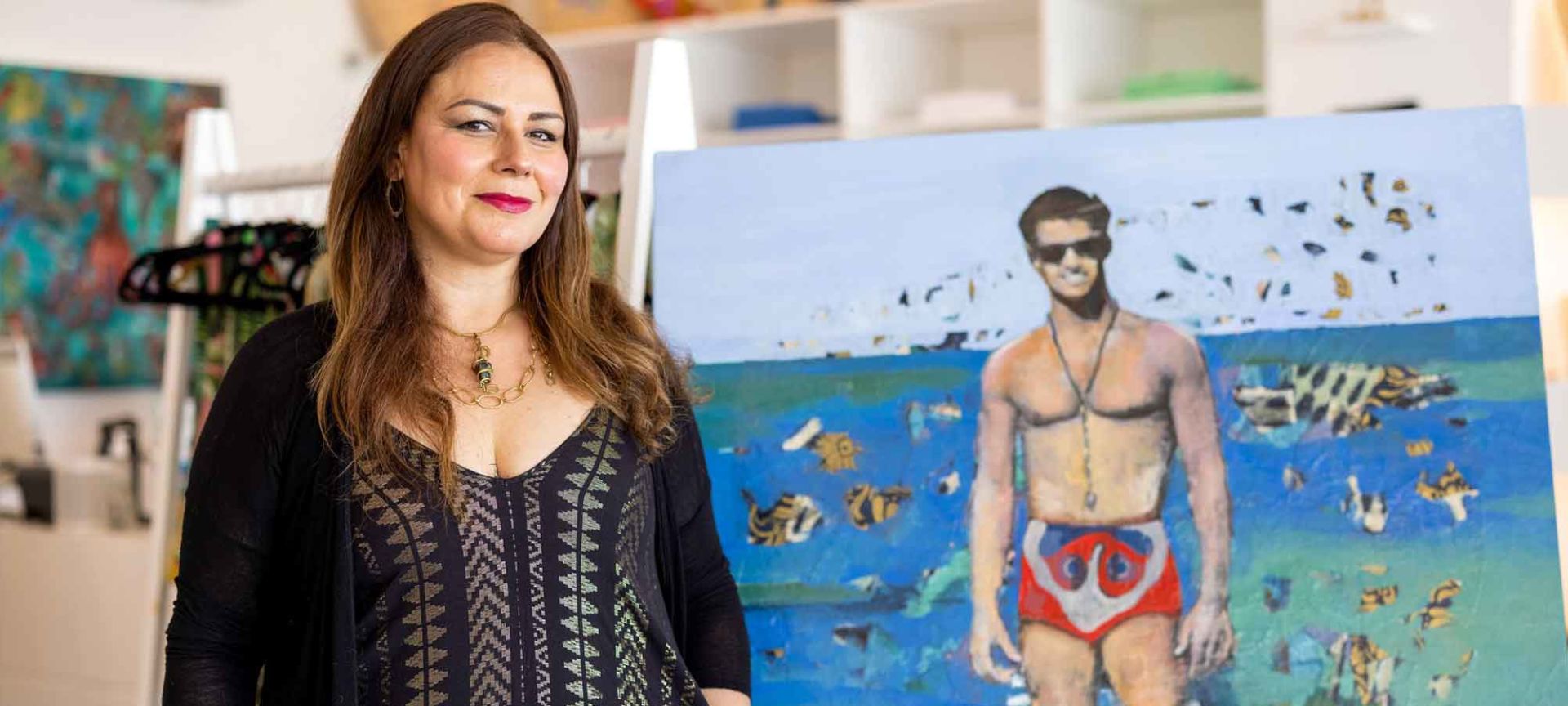 Artist Tanya Talamante Standing in Front of One of Her Paintings