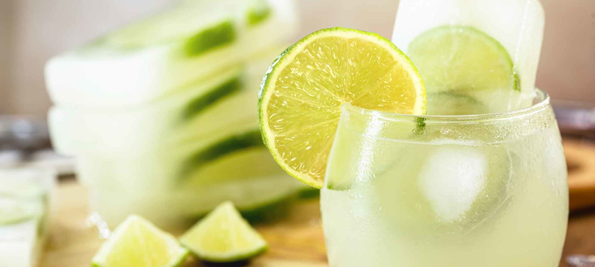 A Glass Of Lemonade With Limes And Slices Of Lemon